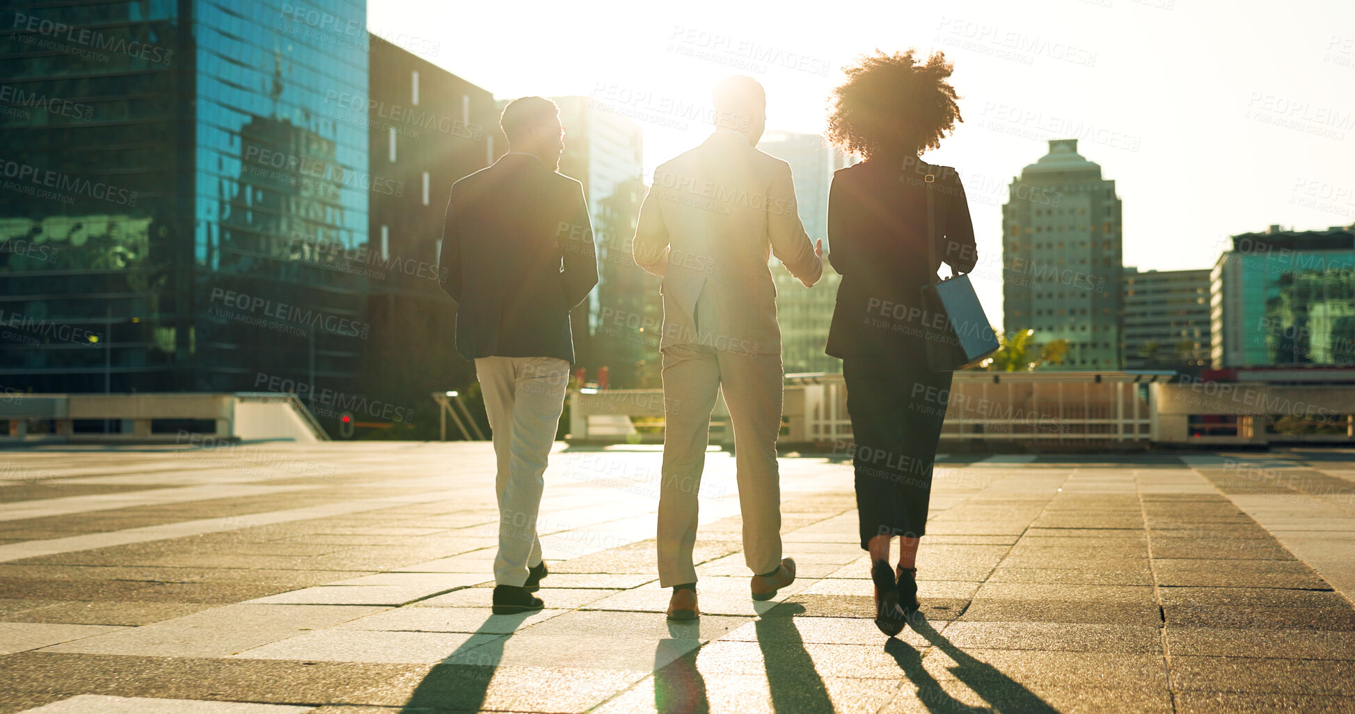 Buy stock photo Back, business team and walking outdoor in city for morning travel to work, conversation and lens flare. Rear View, professional workers and moving in urban town with communication and networking