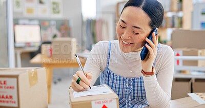 Ecommerce, Asian woman with phone call and package, writing and checking sales and work at fashion startup. Online shopping, boxes and small business owner with smartphone, orders and networking.