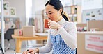 Ecommerce, Asian woman at laptop drinking coffee and typing email, checking sales and work at fashion startup. Online shopping, boxes and small business owner with drink, computer and website at desk