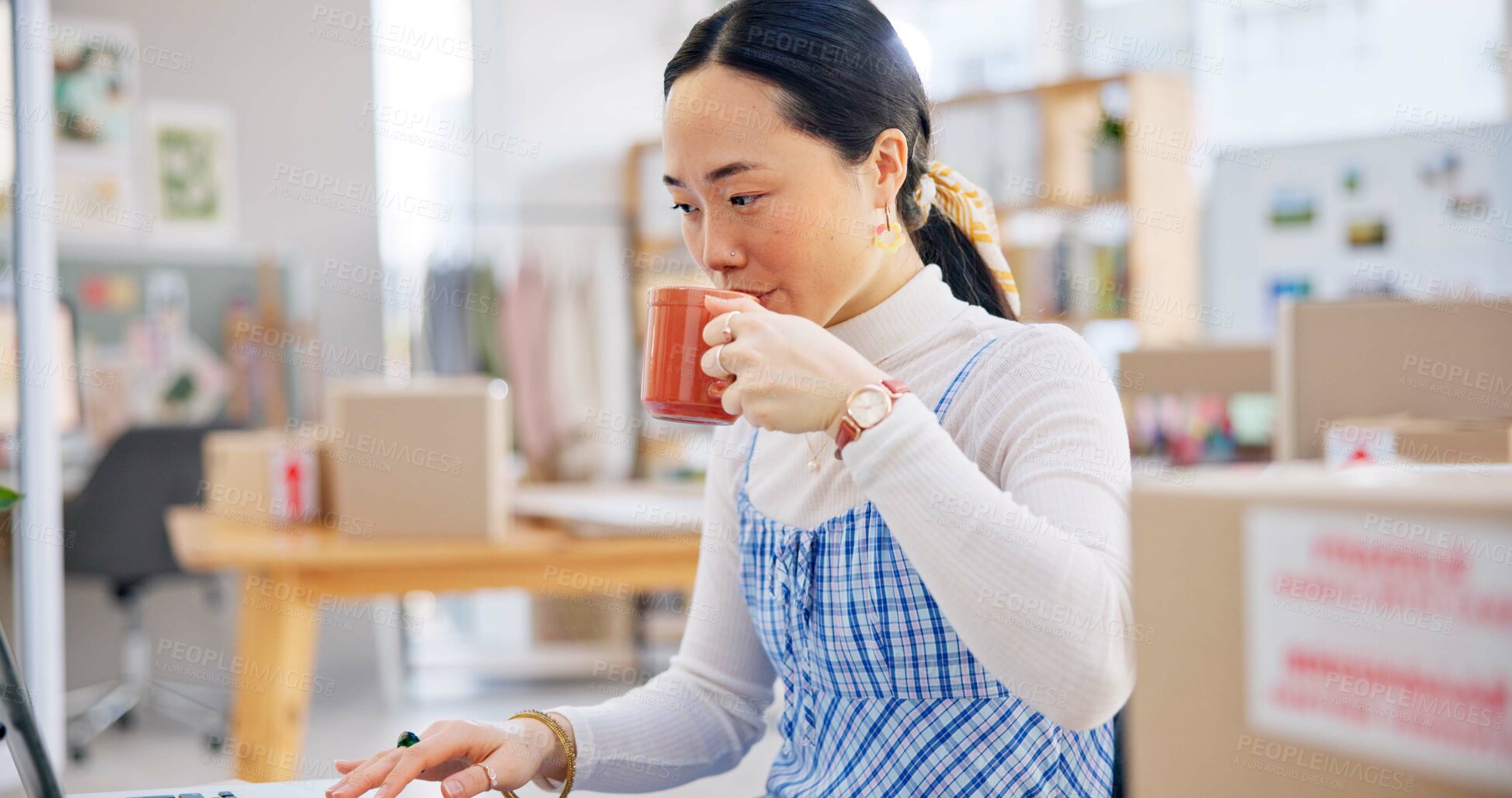 Buy stock photo Ecommerce, Asian woman at laptop drinking coffee and typing email, checking sales and work at fashion startup. Online shopping, boxes and small business owner with drink, computer and website at desk