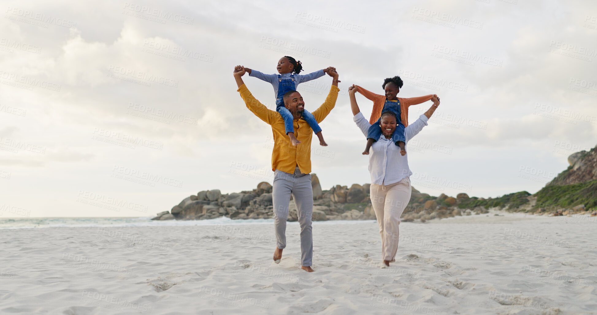 Buy stock photo Family, children on parents shoulders at beach and travel, playful and freedom outdoor with love and bonding. Carefree, energy and holiday with people in nature, mom and dad with kids and happiness