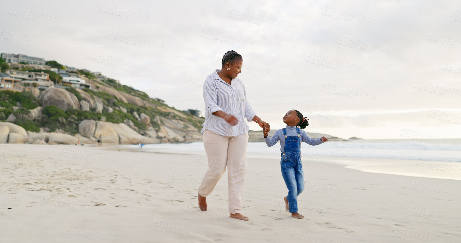 Buy stock photo Black family, mother and daughter holding hands, walk on beach and bonding with love and care outdoor. Happiness, freedom and travel, woman and young girl on holiday with trust and support in nature