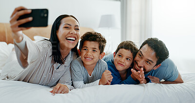 Family selfie, laughing and in a home bedroom for a memory, happy and comedy together. Smile, love and a young mother, father and children taking a photo on a bed in the morning for care and fun
