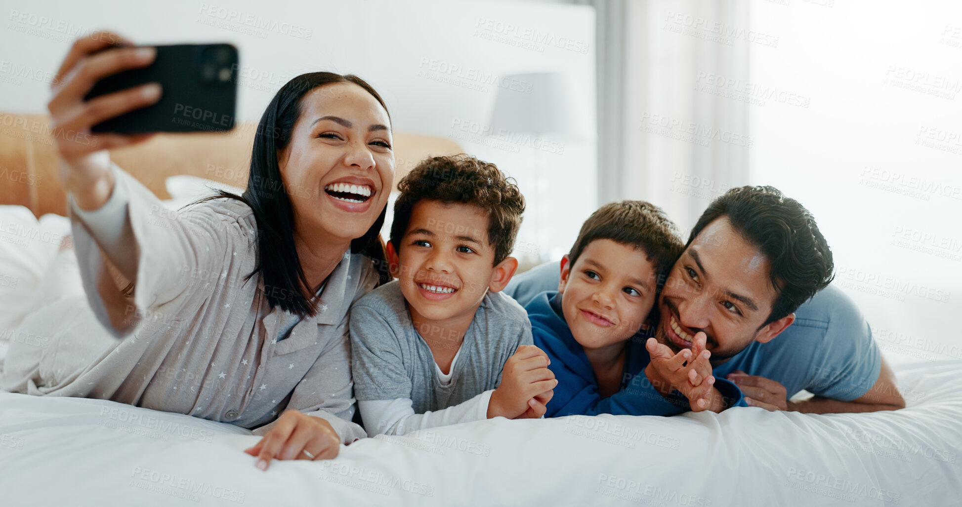 Buy stock photo Family selfie, laughing and in a home bedroom for a memory, happy and comedy together. Smile, love and a young mother, father and children taking a photo on a bed in the morning for care and fun