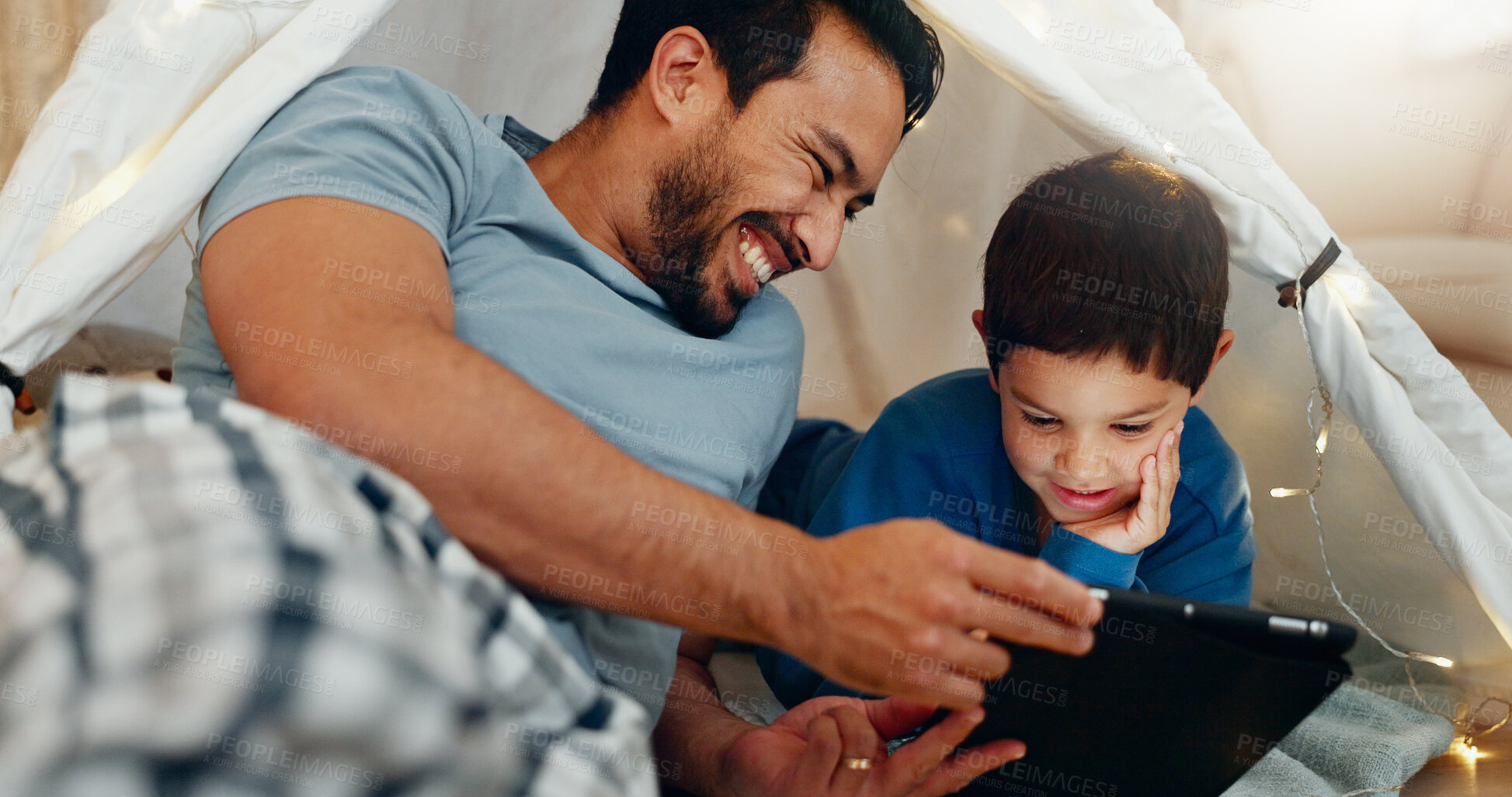 Buy stock photo Bonding, tablet and father in a tent with kid watching a movie, video or show online. Happy, smile and young dad networking on social media with boy kid on digital technology in blanket fort at home.