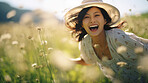 Happy asian woman in field of grass. Laughing and enjoying moment.