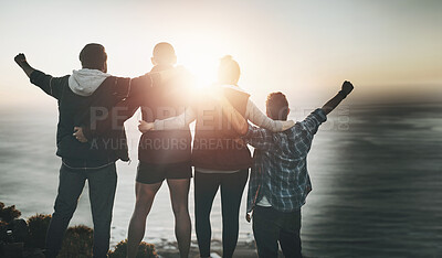 Buy stock photo Rearview shot of a group of friends standing with their arms raised on a mountain cliff