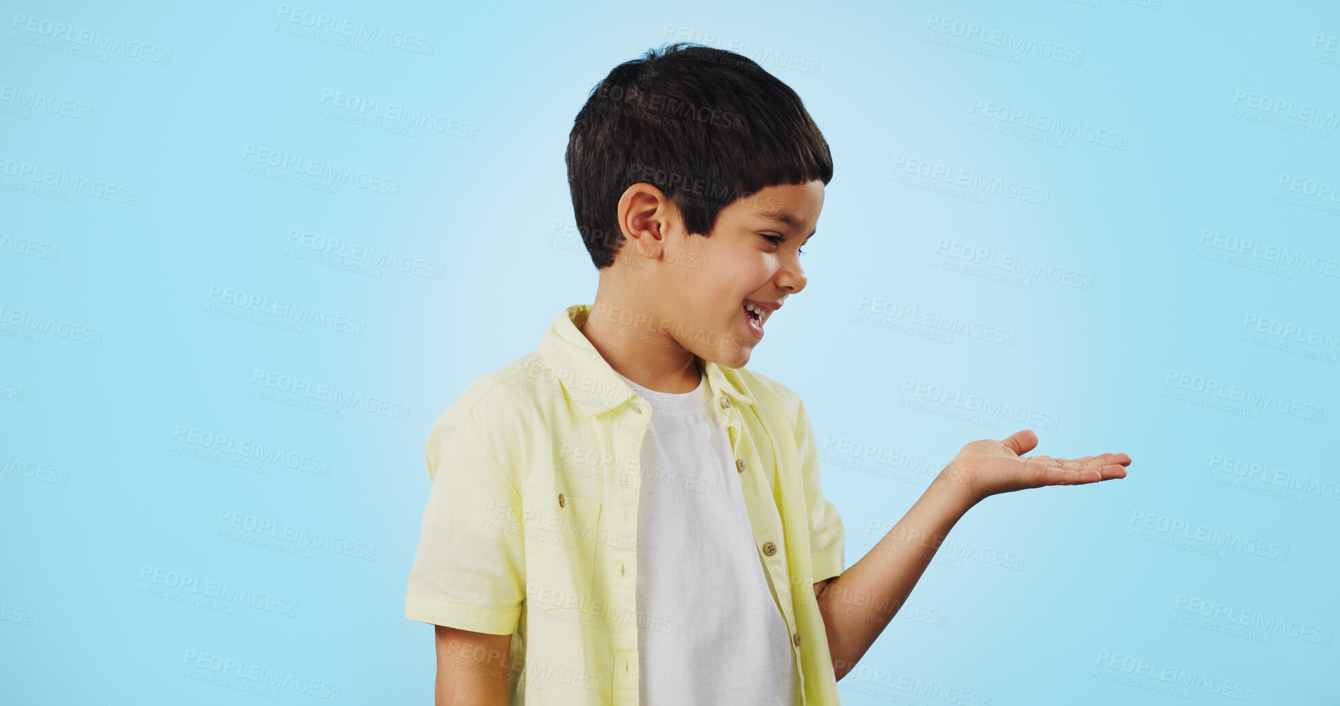 Buy stock photo Kid, smile and happy for presentation in studio on blue background with mockup for product placement. Youth, boy and excited for opportunity, offer or deal on app, social media or digital marketing