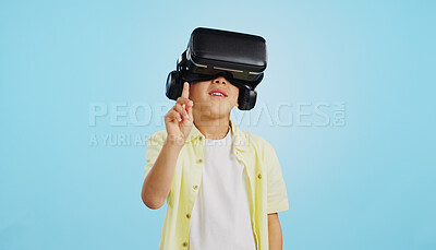VR, child and glasses with video gaming, technology and metaverse online in studio. Young boy, gamer and augmented reality app for streaming and virtual graphic on internet with blue background