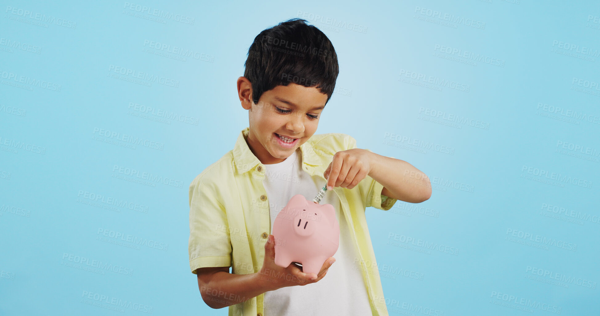 Buy stock photo Piggy bank, cash and child face with money, savings and cash planning in a studio, Happy, portrait and young boy with allowance and safe for bills, wealth and budget with blue background and smile