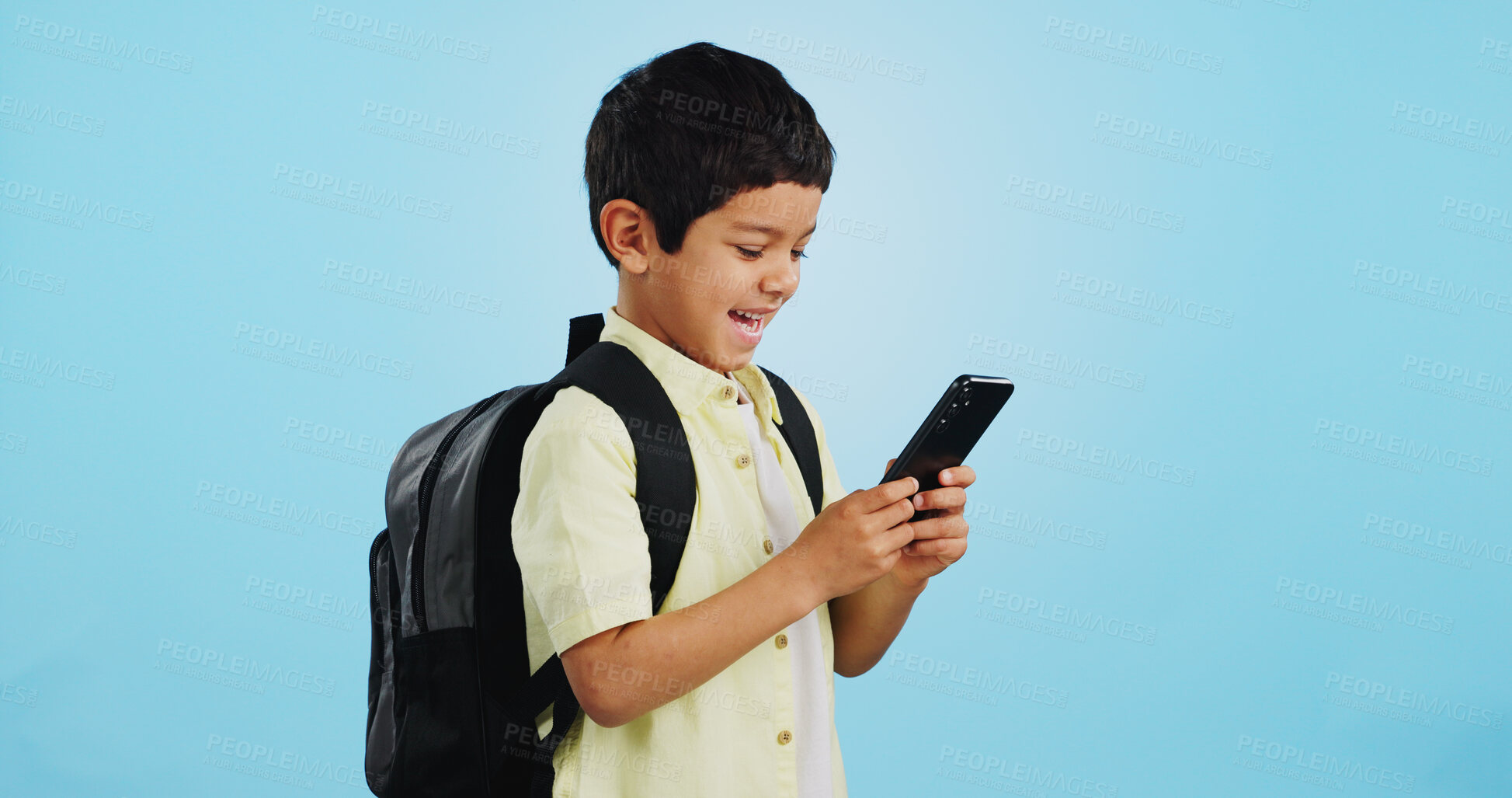 Buy stock photo School, phone or kid on social media in studio typing to chat, play mobile games or download app. Blue background, student or happy boy child reading notification for online education or tech search