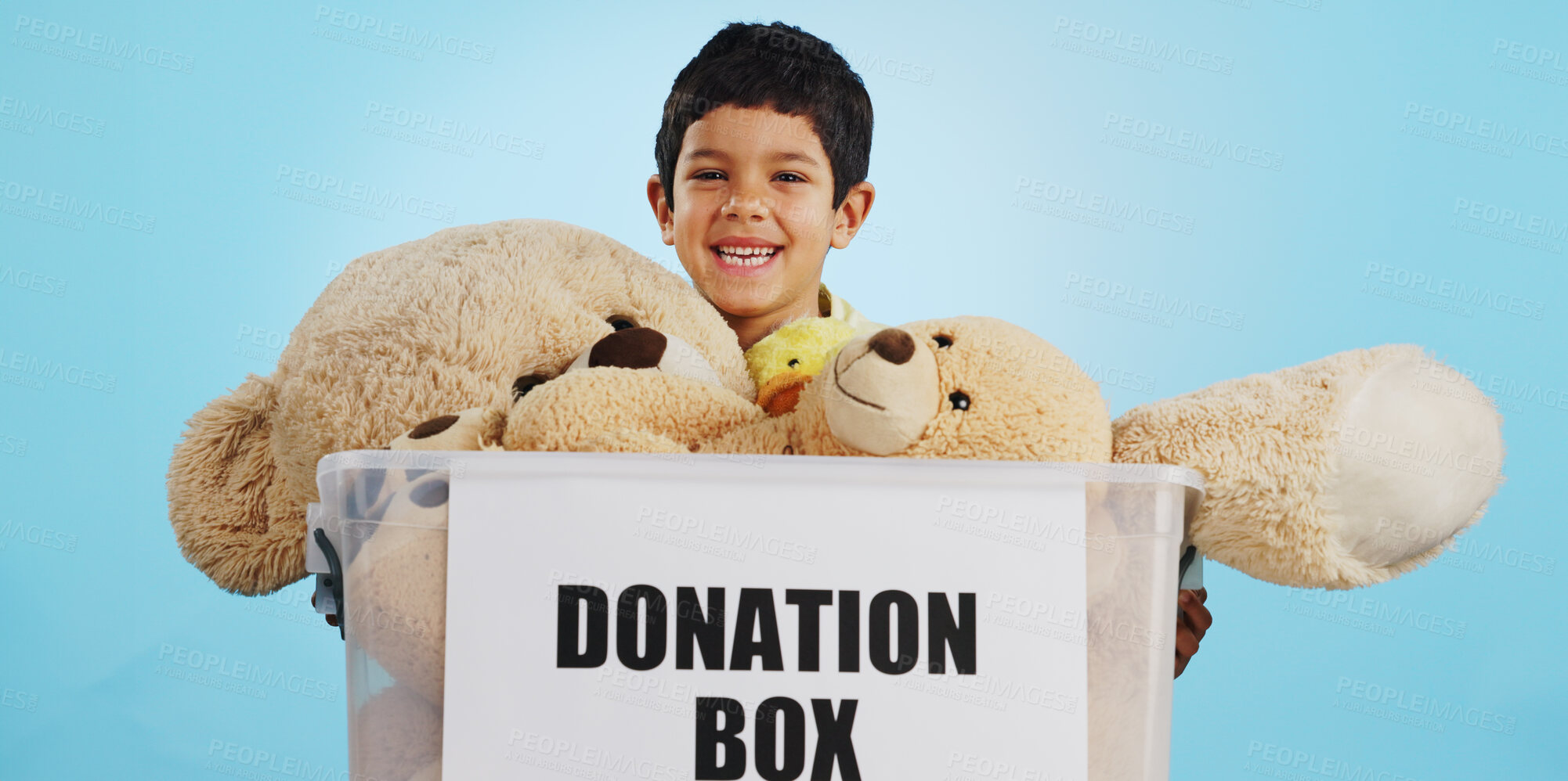 Buy stock photo Boy in studio with toys, donation in box and smile for children, social charity and hope in kindness. Care, donate and happy kindergarten child with teddy bear package at kids ngo on blue background.