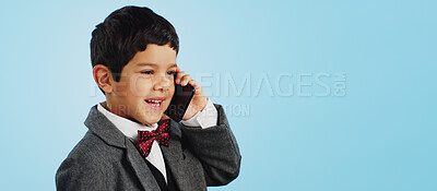 Child, talking and boy with phone call in studio, blue background and mockup with telephone chat or conversation. Calling, kid and speaking with cellphone communication or discussion with mobile