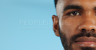 Half, face and serious black man in studio, blue background and mockup space with confidence or advertising. Portrait, closeup and marketing for skincare, wellness or healthy dermatology care
