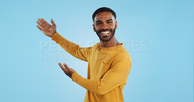 Happy, face and man with hand pointing in studio for news, presentation or platform offer on blue background. Smile, portrait and male model show promo, launch or space for coming soon announcement
