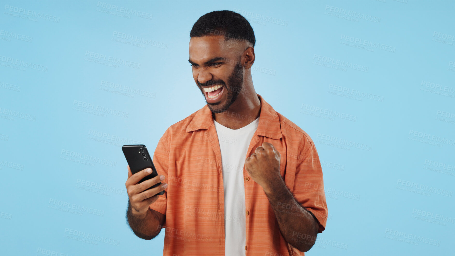 Buy stock photo Man, fist celebration and phone in studio for esports, gambling and profit with trading by blue background. African person, investor and smartphone with fintech app, lotto and revenue on stock market