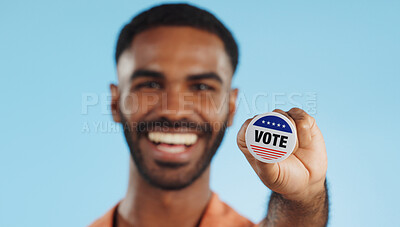 Vote pin, man and face with badge for politics, government and voting register for election. Studio, blue background and voter choice with administration decision with a smile and happy from support