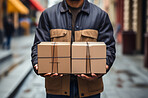 Delivery man holding packages standing in street. Delivery concept.