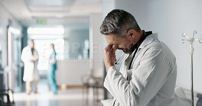 Stress, grief or fail with a mature doctor in a hospital looking unhappy for healthcare or medical. Depression, mistake or loss with a sad man medicine professional in a professional medicare clinic