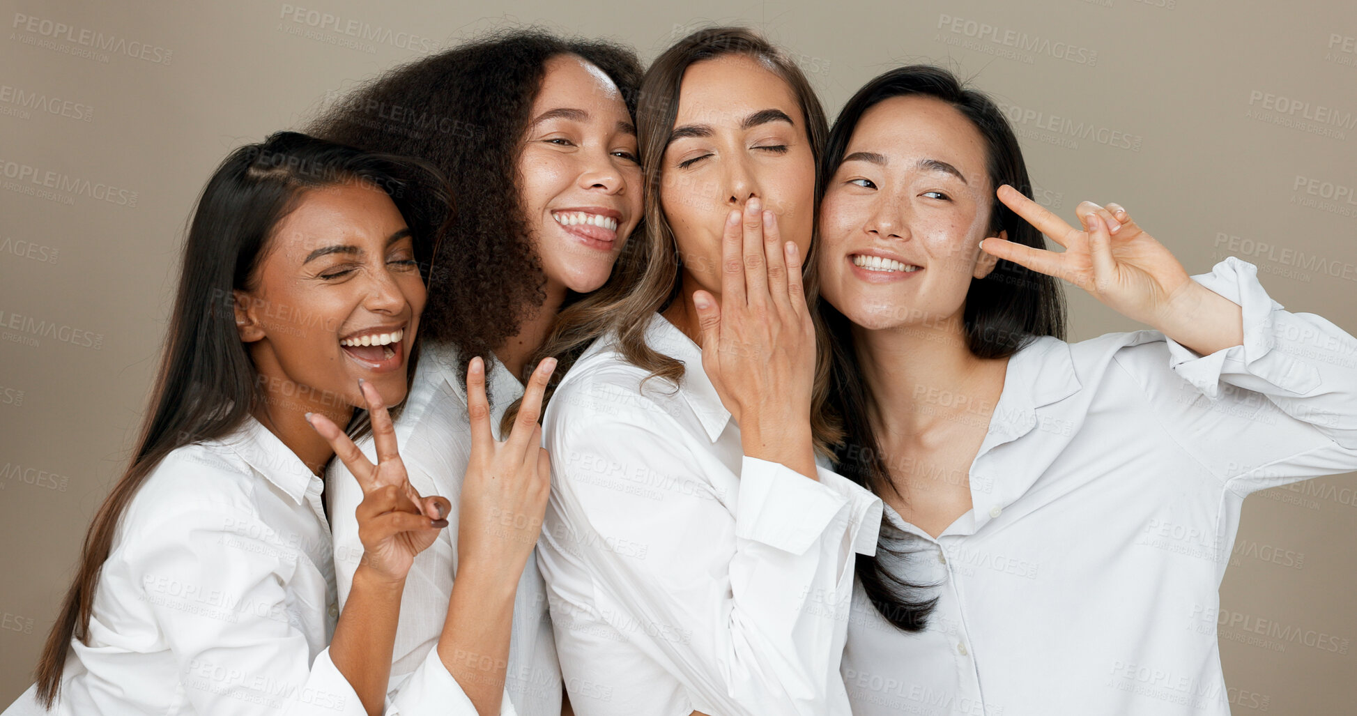 Buy stock photo Diversity, peace sign and group of women in studio for empowerment, wellness and community. Emoji, friends and people hug, blow kiss and smile for beauty, inclusion and support on brown background