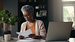 Laptop, documents and finance with a senior woman busy on a budget review or pension fund