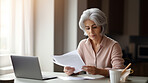 Laptop, documents and finance with a senior woman busy on a budget review or pension fund