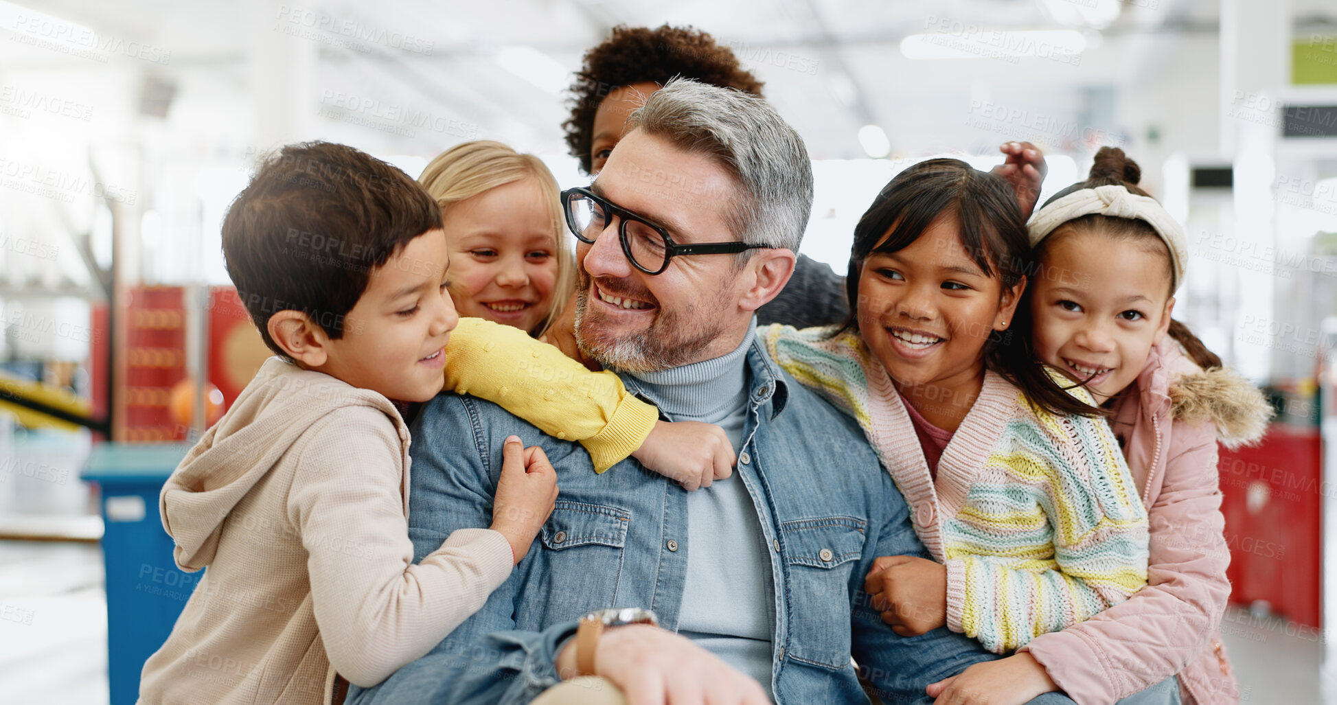 Buy stock photo Hug, children and male teacher with happiness, smiling and excited for bonding, friends and education. Kids, embrace and memories for girls, boys and diversity in classroom, together and knowledge