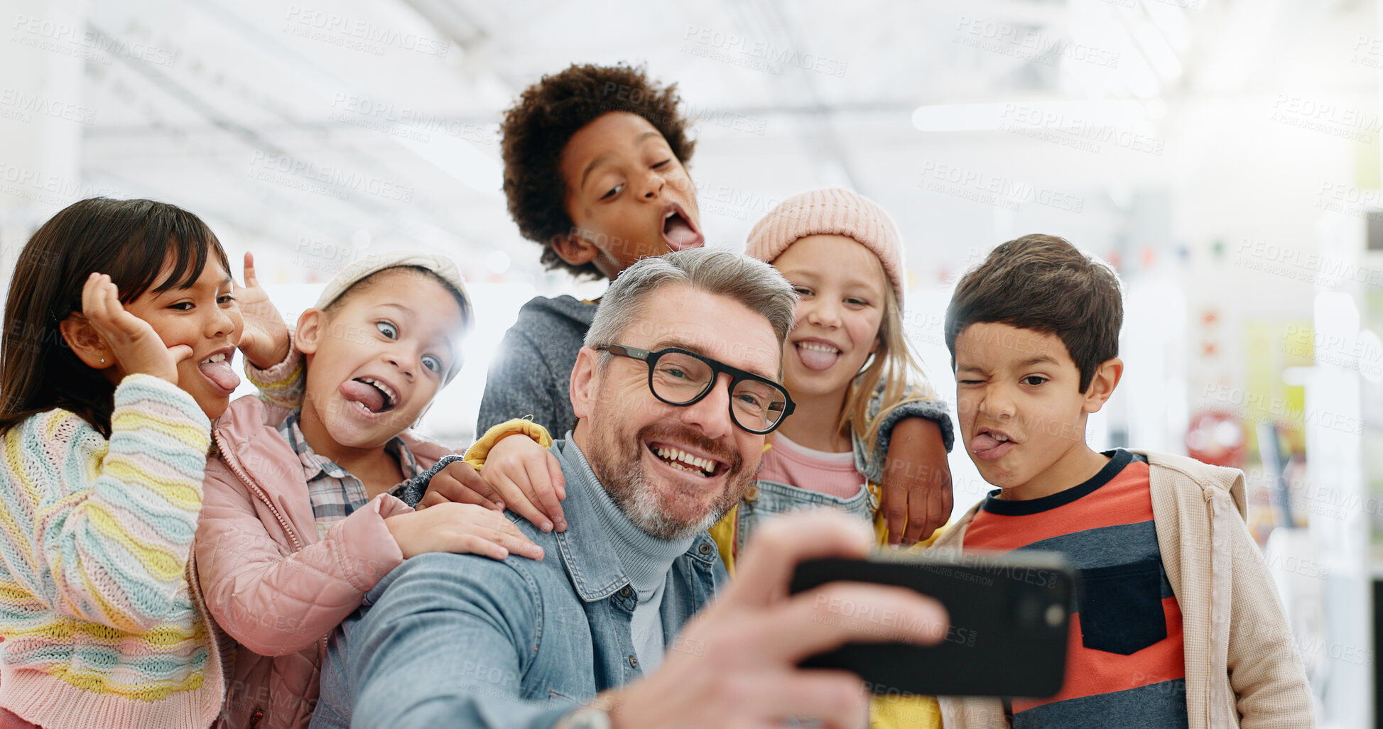 Buy stock photo Selfie, children and teacher with funny face, smile and picture with educator, excited and happy. Kids, internet and cellphone for technology, online and memories for school, classroom or diversity