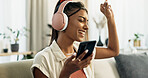 Phone, music and happy woman dance on sofa in home, singing and listening to audio. Smartphone, excited Indian person on headphones and radio, sound or freedom in living room on mobile app technology