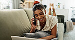 Laptop, happy or Indian woman on a phone call on a sofa or couch to relax in living room or apartment. Smile, communication or person on mobile conversation with cellphone in lounge of modern home