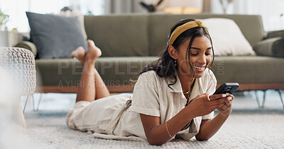 Woman, phone and lying on floor with communication, typing or social media scroll in living room of home. Indian, girl and smartphone on ground for chat, texting or technology with internet in lounge