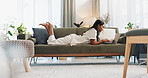 Woman, laptop and lying on sofa with communication, typing or social media scroll in living room of home. Indian, girl and pc on couch for web search, streaming or technology with internet in lounge