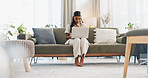 Woman, laptop and typing on sofa for communication, email or social media scroll in living room of home. Indian, girl and pc on couch for web search, streaming or technology with internet in lounge