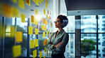 Woman looking and brainstorming with ideas on glass board and sticky note