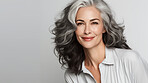 Portrait of mature woman with curly wavy grey hair. Hair care, make-up and hair health