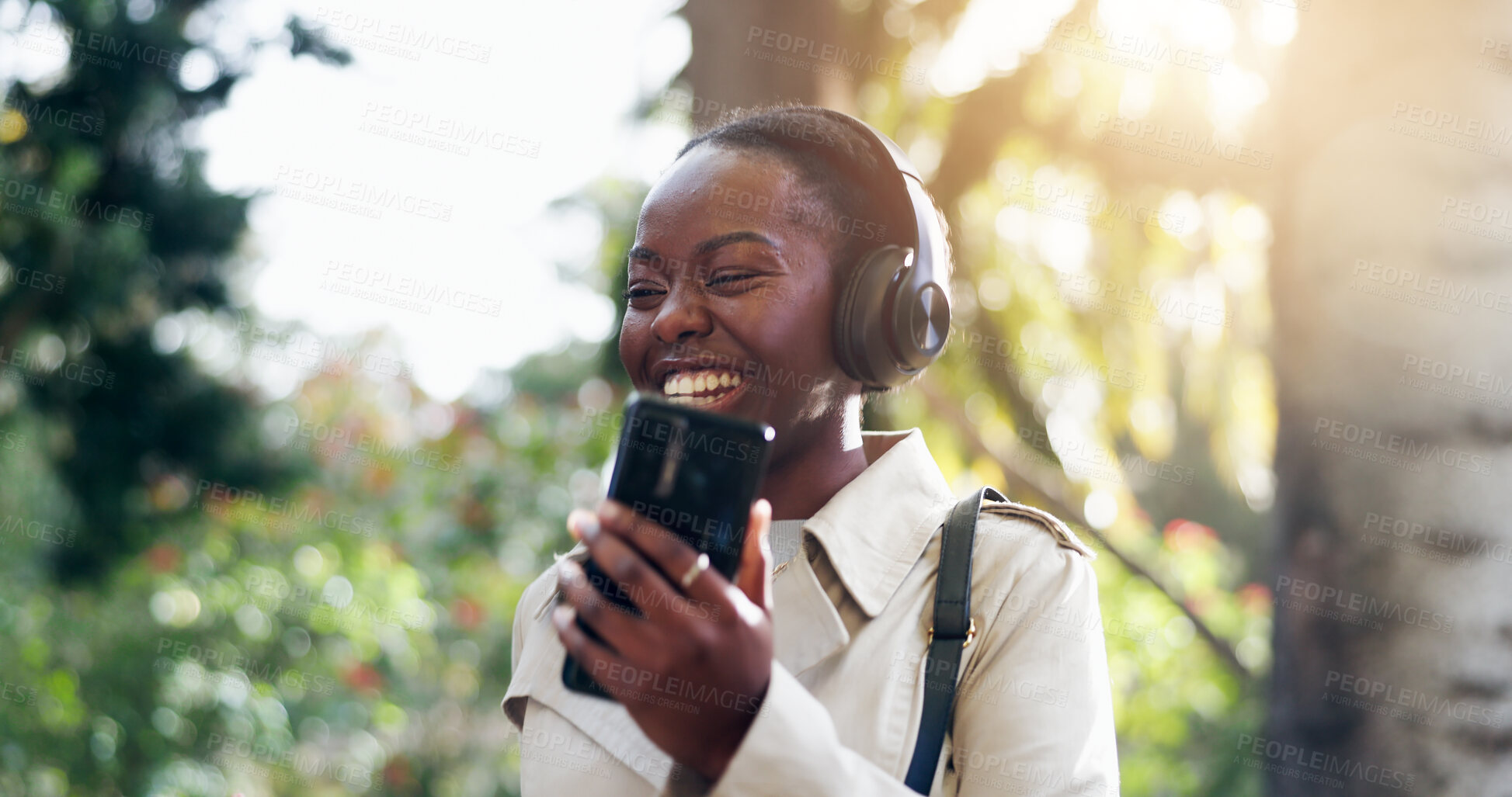 Buy stock photo Smile, phone and woman with headphones for fun, funny and podcast or song, energy and relax in outdoors. Black female person, streaming radio and music or audio, nature and internet on smartphone