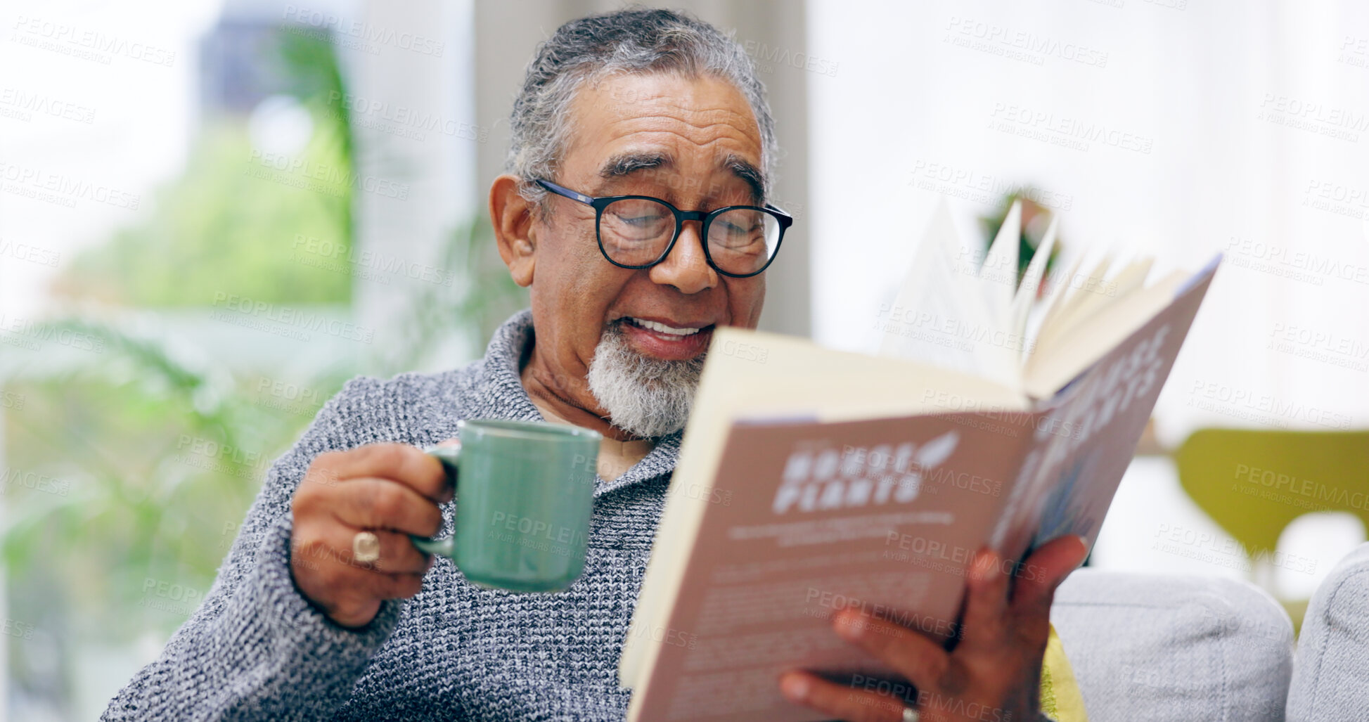 Buy stock photo Elderly man, book and coffee on sofa with smile, reading or relax in retirement in home living room. Senior african person, literature and happy with tea for knowledge, thinking and drink on couch