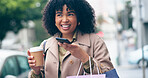 Happy woman, coffee and phone for communication for outside, city and street for commute. African, business person and smile with shopping bags while talking on mobile  with app, network or internet