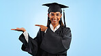 Graduation, portrait and happy woman point, palm gesture and advertising learning, university info or college study. Studio mockup space, student commercial ads or school graduate on blue background
