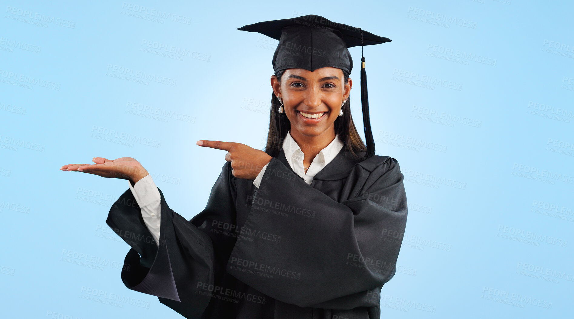 Buy stock photo Graduation, portrait and happy woman point, palm gesture and advertising learning, university info or college study. Studio mockup space, student commercial ads or school graduate on blue background