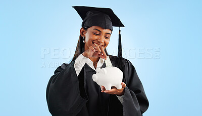 Woman, graduation and piggy bank in studio, saving and cash for investing, future or goals by blue background. Student girl, banking and money with thinking, decision and choice for financial wealth