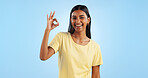 Happy woman, OK hand gesture and agreement for success or support, smile and mockup space on blue background. Like, yes and emoji with feedback, vote or opinion in studio with thank you or praise
