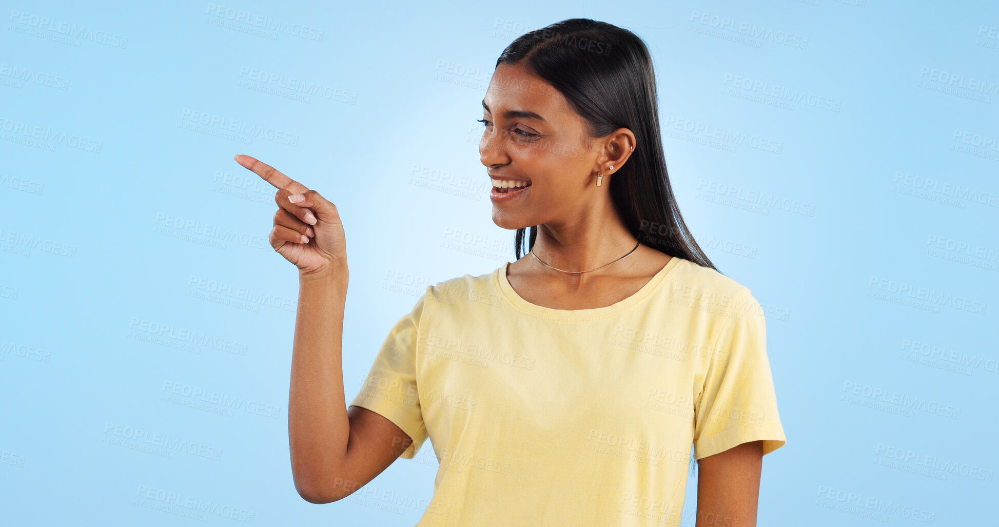 Buy stock photo Woman, pointing and deal with marketing, information and direction for announcement in studio. Blue background, person and promotion with smile and sale with offer and show hand sign of student