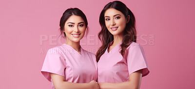 Friendly medical doctors or nurses in pink uniform scrubs on copyspace background.