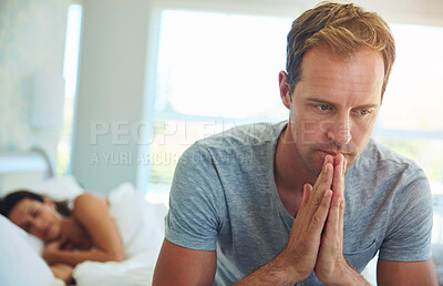 Buy stock photo Shot of a man looking worried while his wife sleeps in the background
