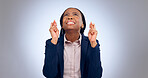 Business woman, fingers crossed and hope in studio for luck, thinking of wish or waiting for announcement on grey background. Nervous african worker, hand emoji or anxiety while praying for good news