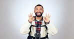 Perfect sign, hiker and portrait of man in a studio with a backpack for hiking adventure. Happy, smile and young male person from Mexico with ok hand gesture for camping isolated by gray background.