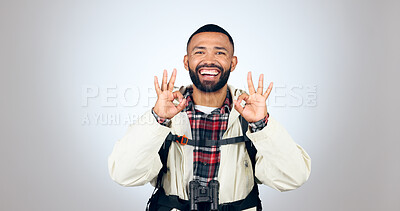 Buy stock photo Perfect sign, hiker and portrait of man in a studio with a backpack for hiking adventure. Happy, smile and young male person from Mexico with ok hand gesture for camping isolated by gray background.