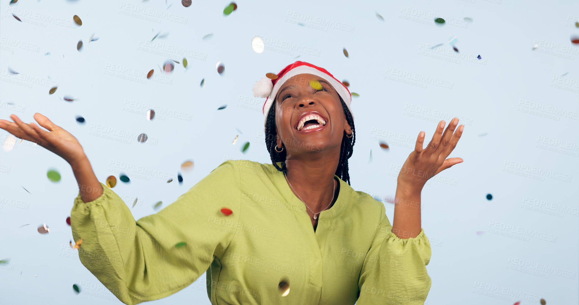 Buy stock photo Christmas, confetti and black woman with celebration, party or happiness on blue studio background. African person, girl or model with glitter, excited or event with joy, Xmas or winning with holiday