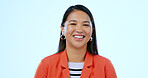 Happy, headshot and portrait of Asian woman in a studio with positive, good and confident attitude. Excited, smile and closeup face of young female person with happiness isolated by blue background.